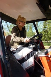 Helena vom Campingplatz in "Puolanka" sitzt zum ersten Mal auf einem Traktor